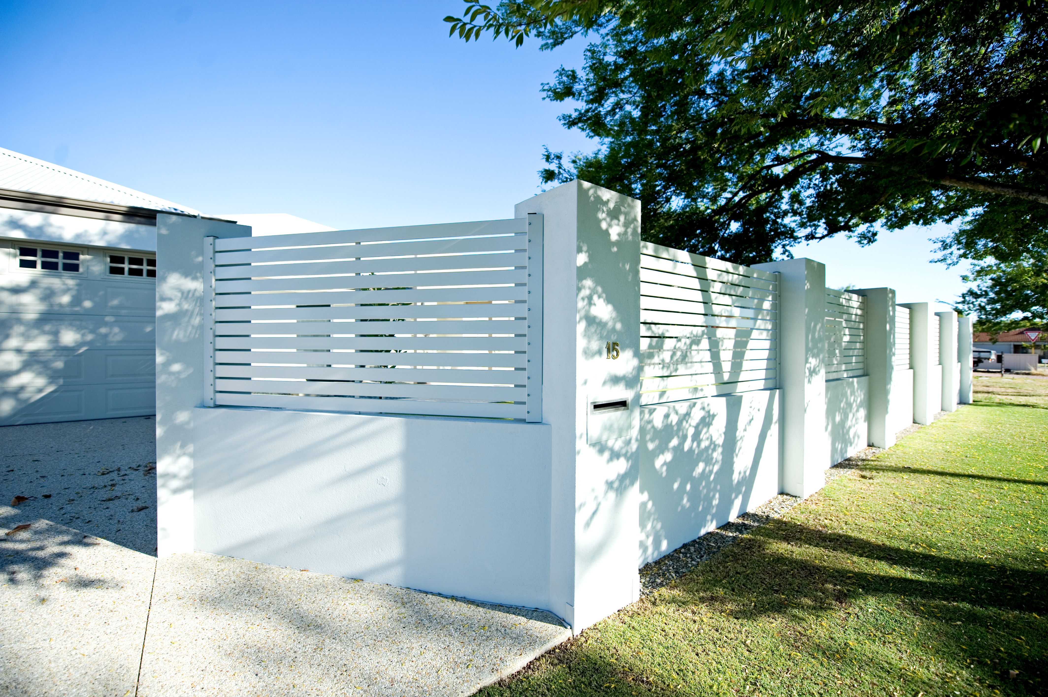 White horizontal slat fence with rendered pillars